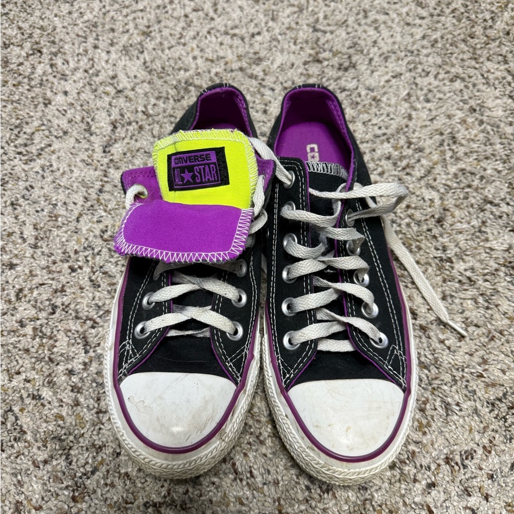 Converse All Stars black with purple trim and yellow accent.